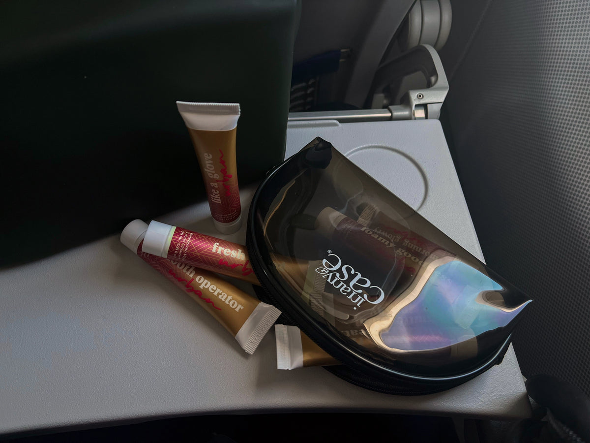 Il set Urban fuori dalla beauty bag sul tavolino di un aereo, con lo schienale e la chiusura del tavolino in campo