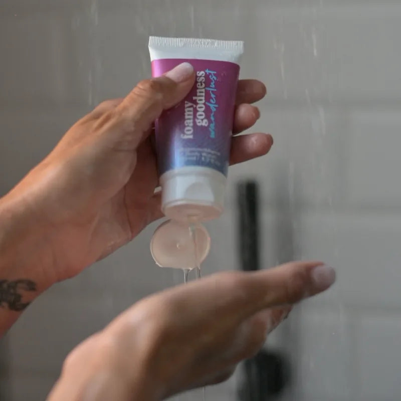 Il tubo del bagnoschiuma che lascia cadere il gel sulla mano