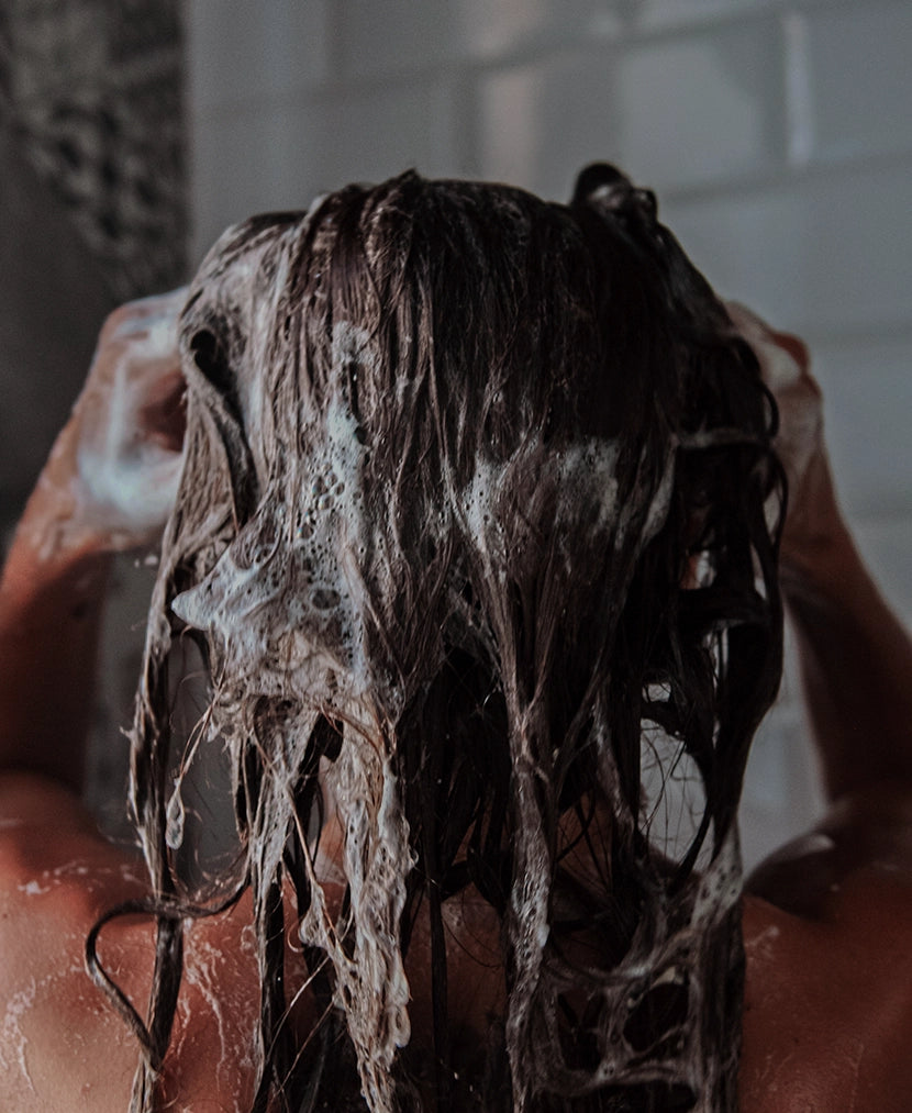 Il tubo dello shampoo spremuto sotto la doccia