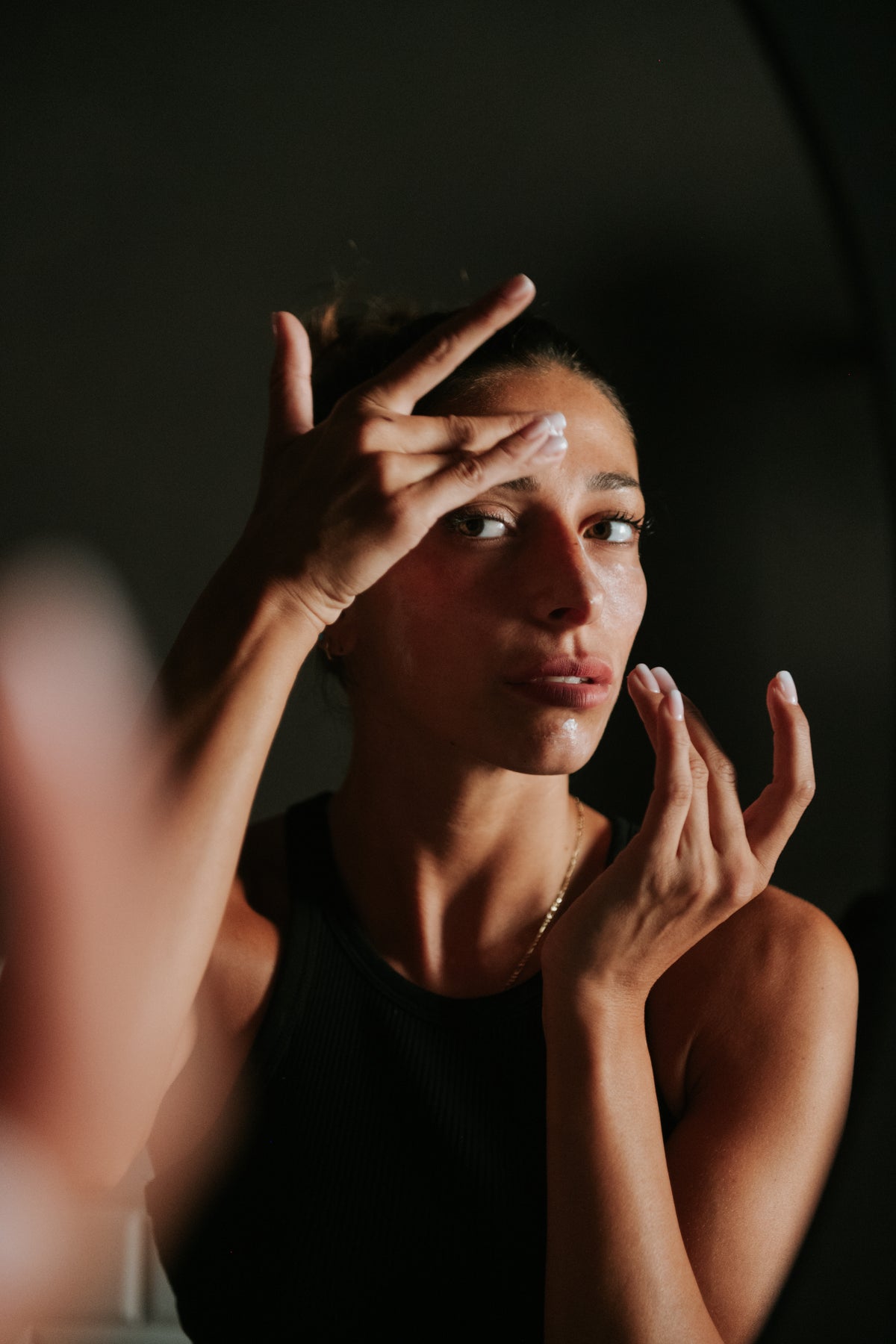 Una donna che applica la crema viso con le dita