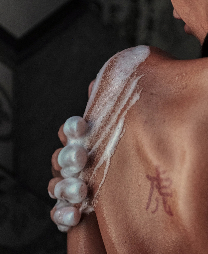 Il tubo del bagnoschiuma che lascia cadere il gel sulla mano