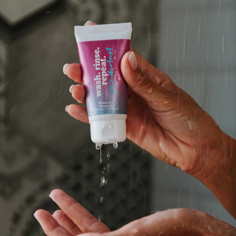 Il tubo dello shampoo spremuto sotto la doccia